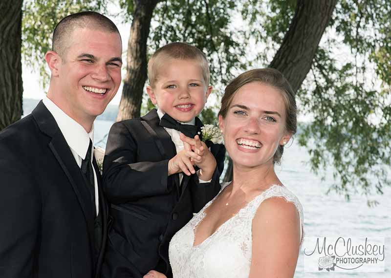 Bride and groom holding a child