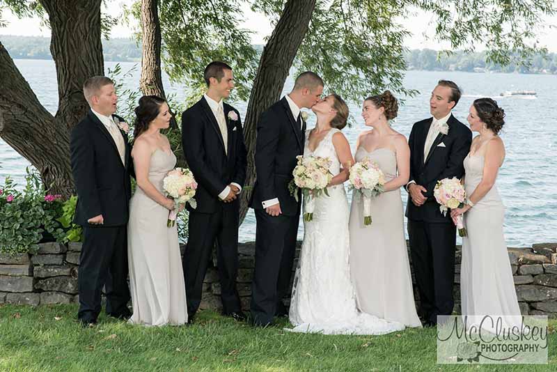 Wedding party witnessing bride and groom kiss