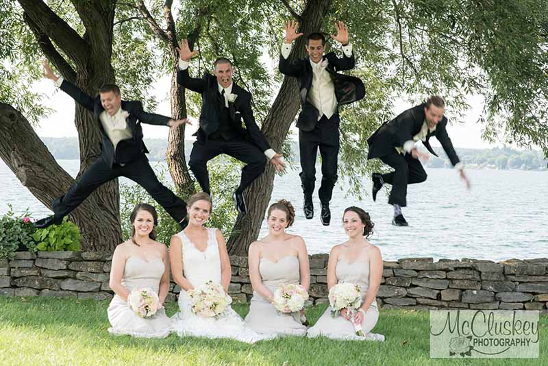 Groom and groomsmen jumping over bride and bridesmaids