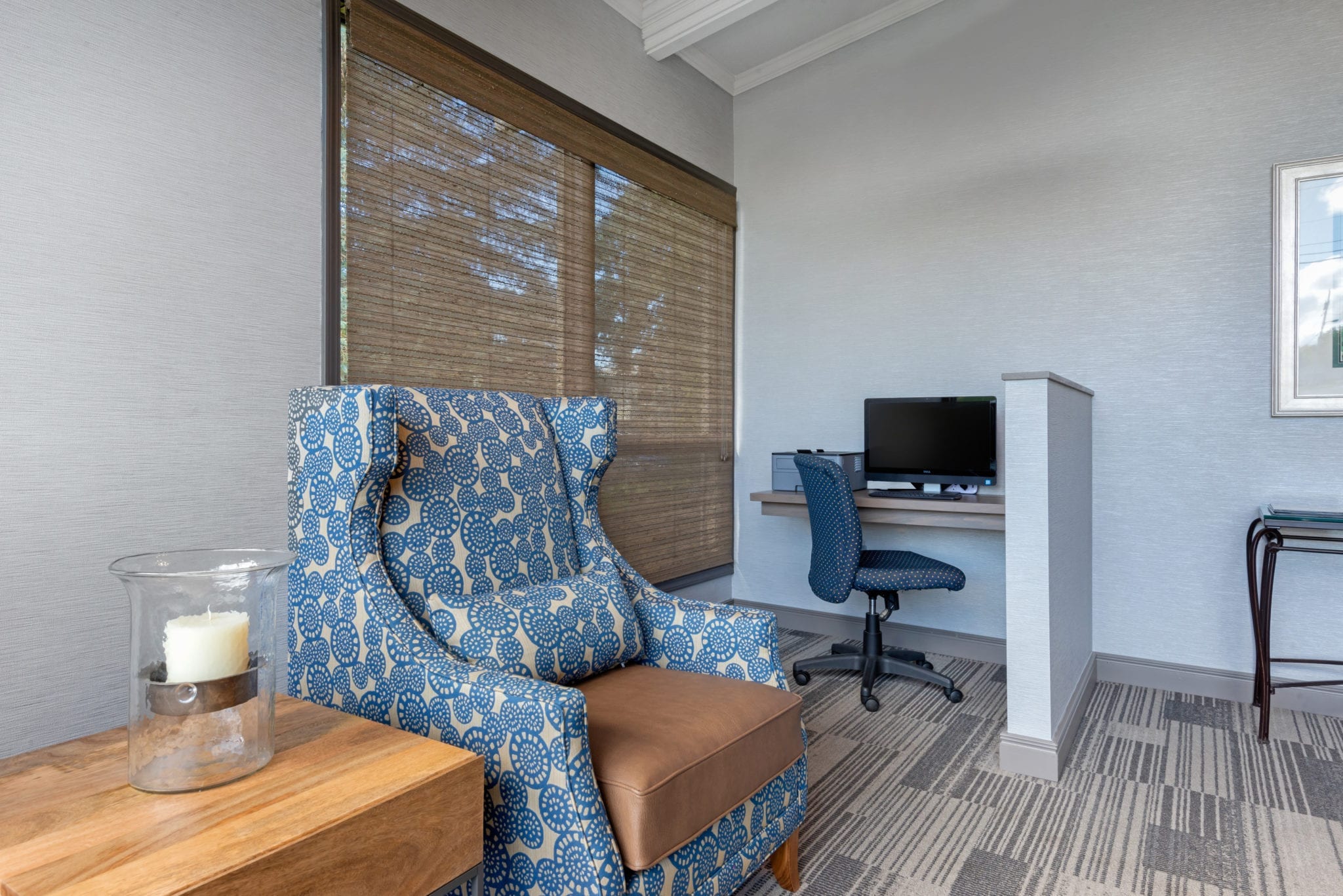 Blue patterned chair and small computer desk.