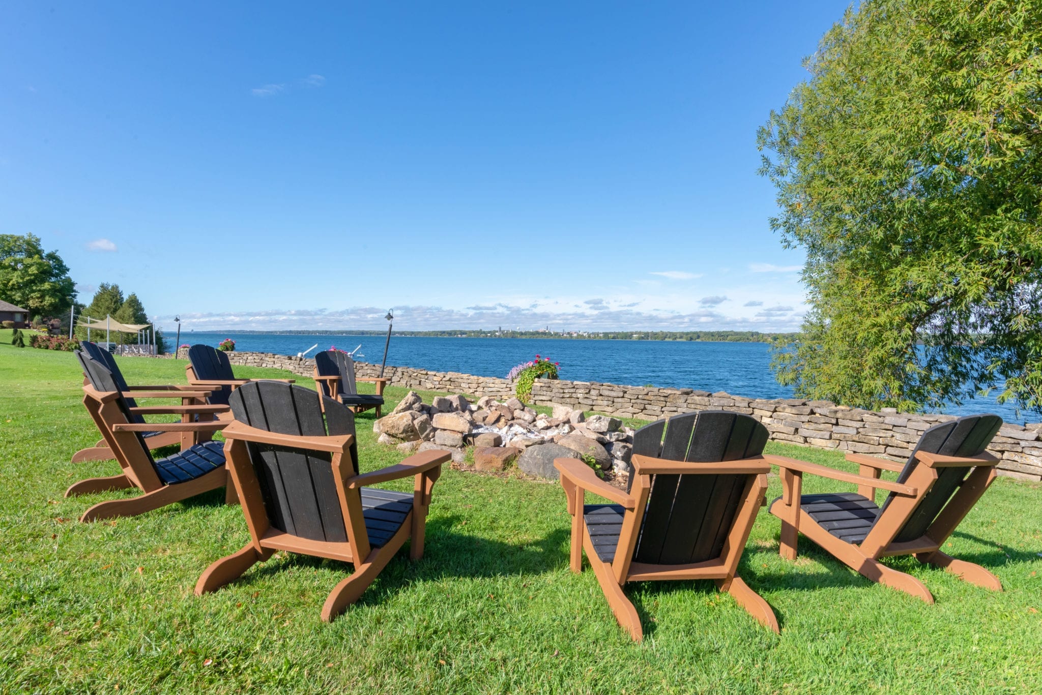 Wooden lounge chairs around a fire pit.