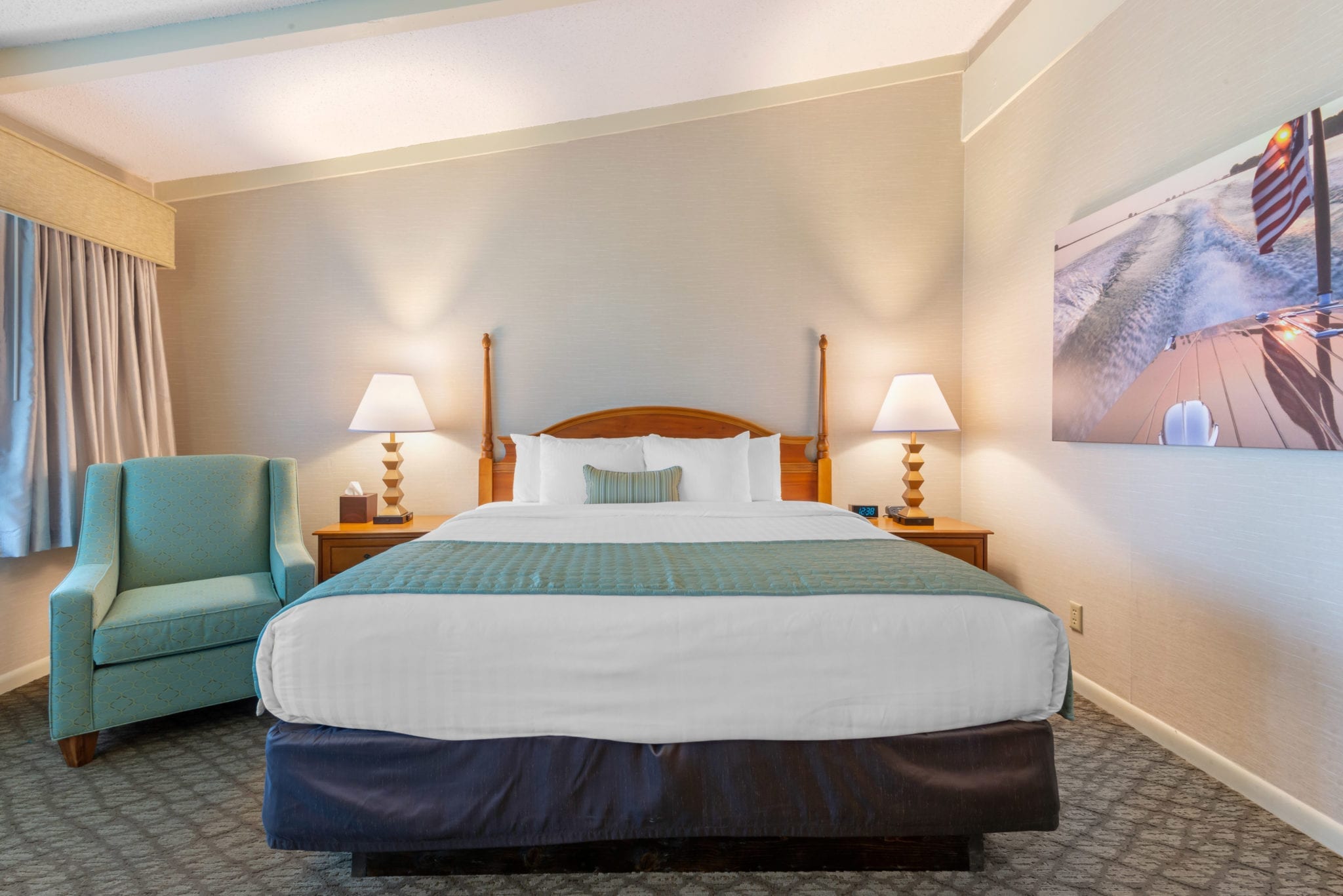 Bedroom with queen bed and lounge chair.